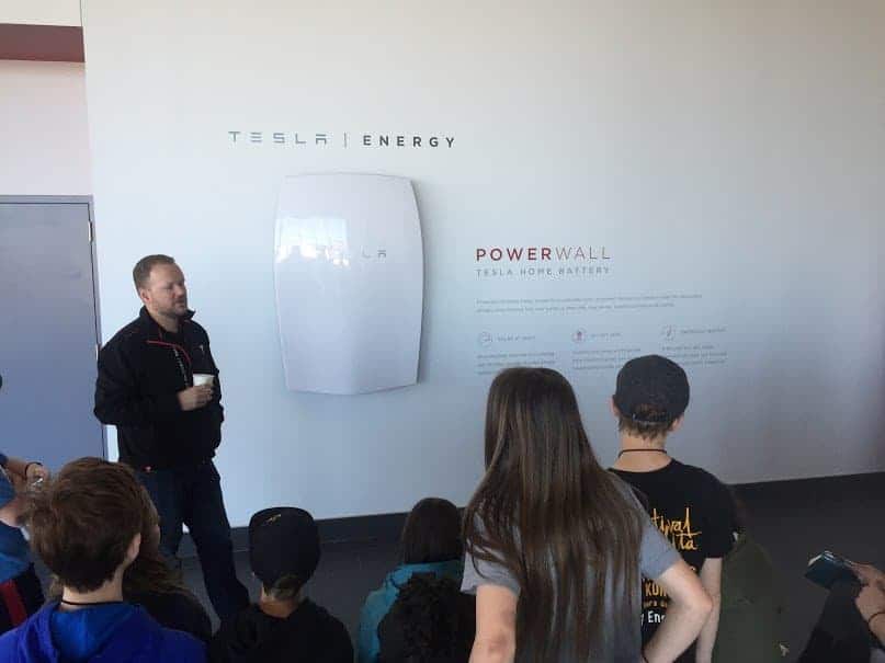 students listening to a tesla employee
