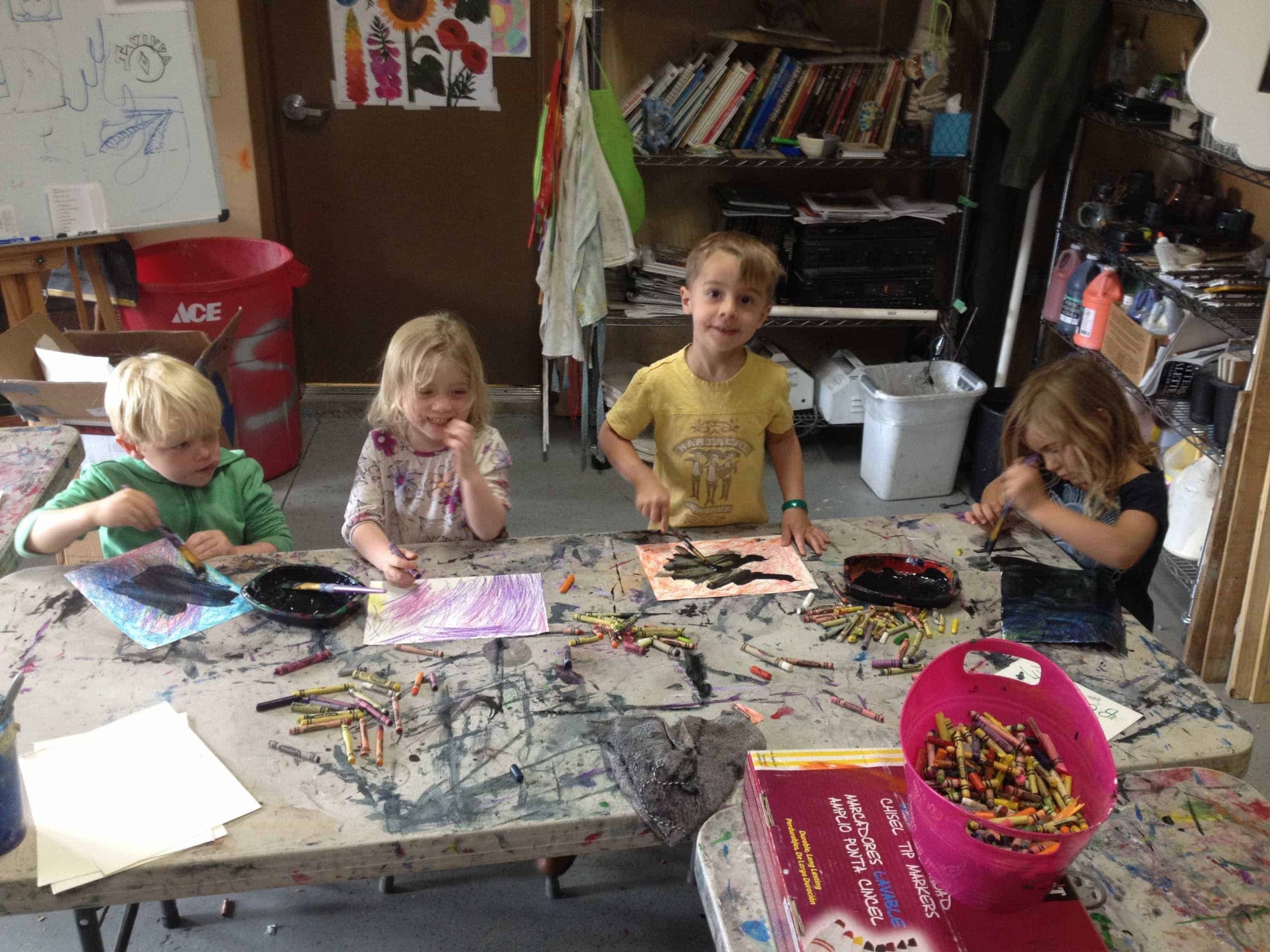 students standing and making art at a desk