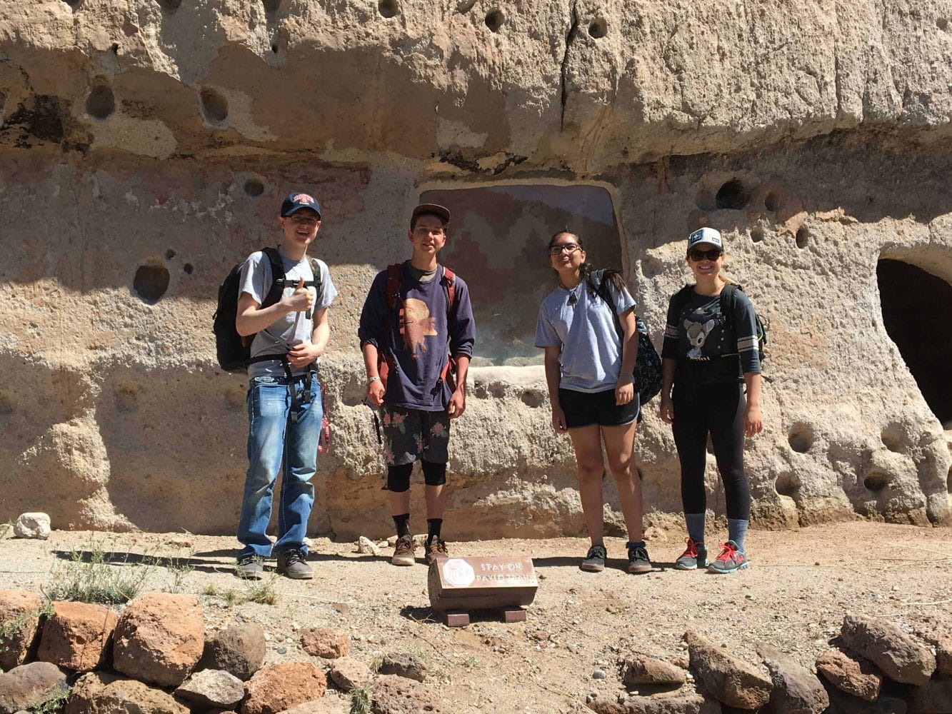 students standing in front of a cave