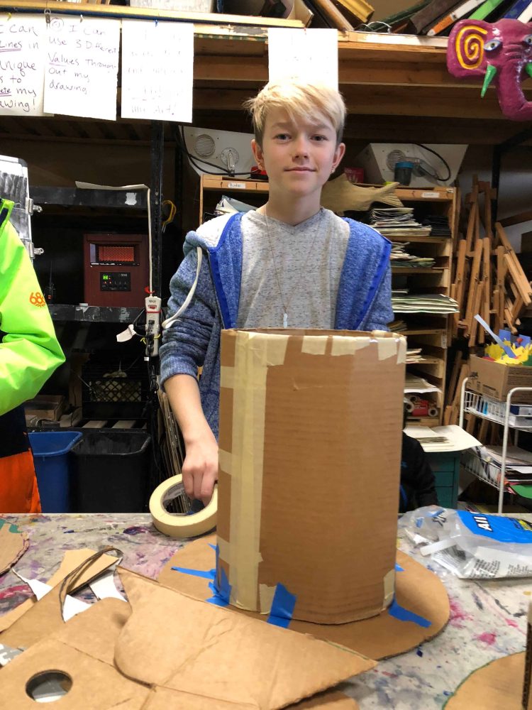 student working on his cardboard hat