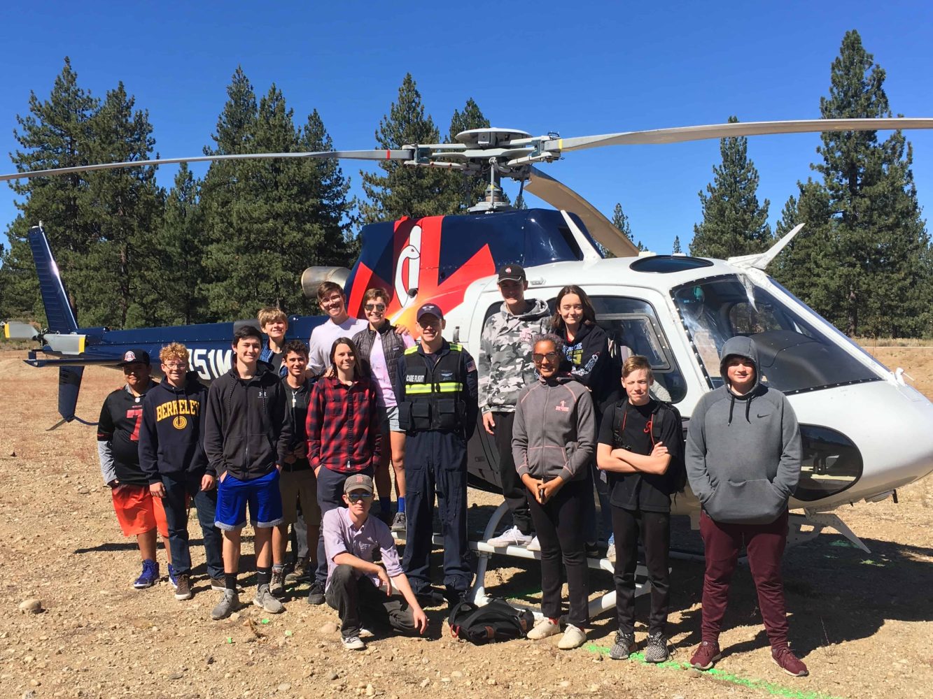 students in front of a helicopter