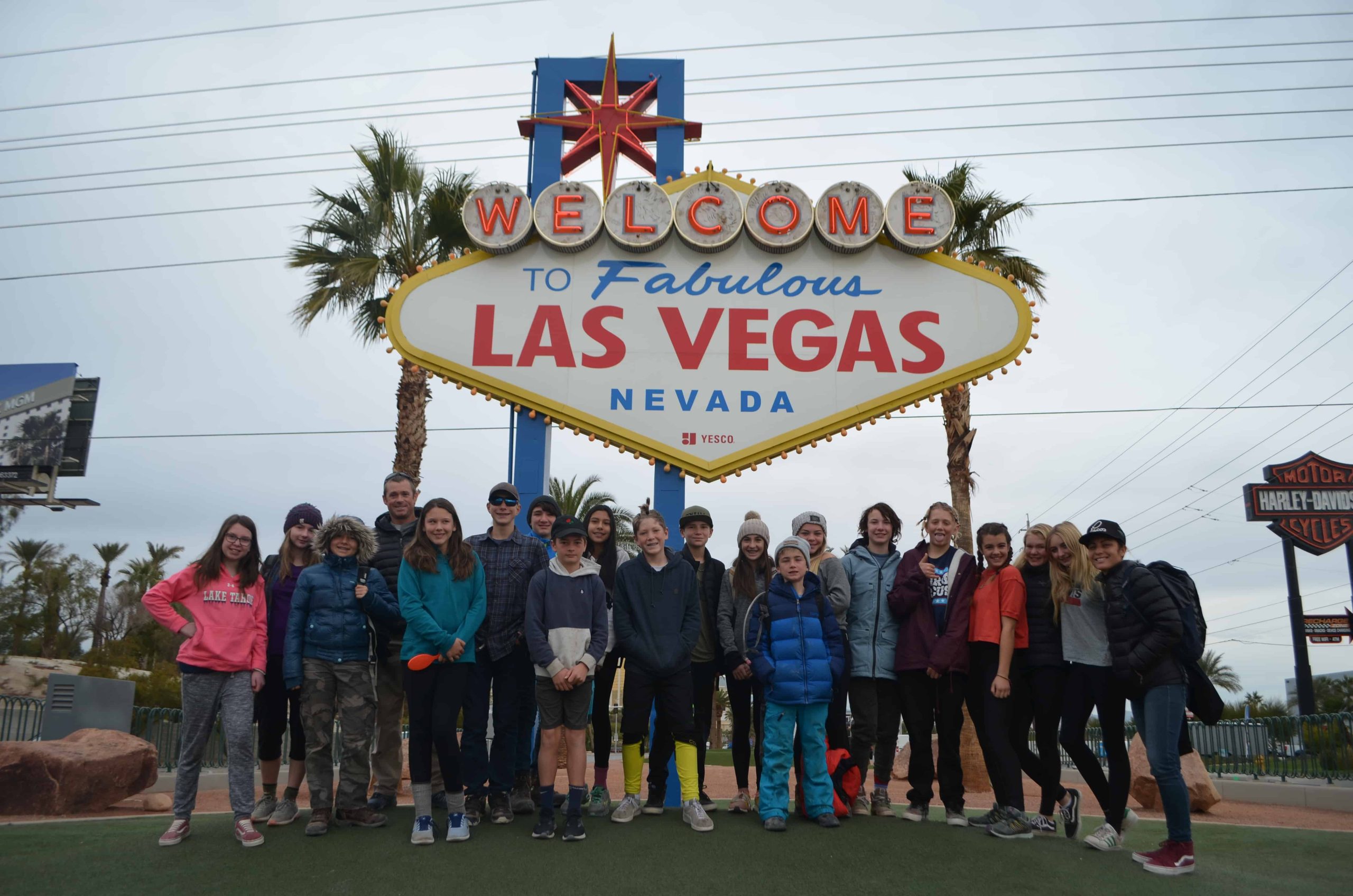 students standing in front of the welcome to las vegas sign