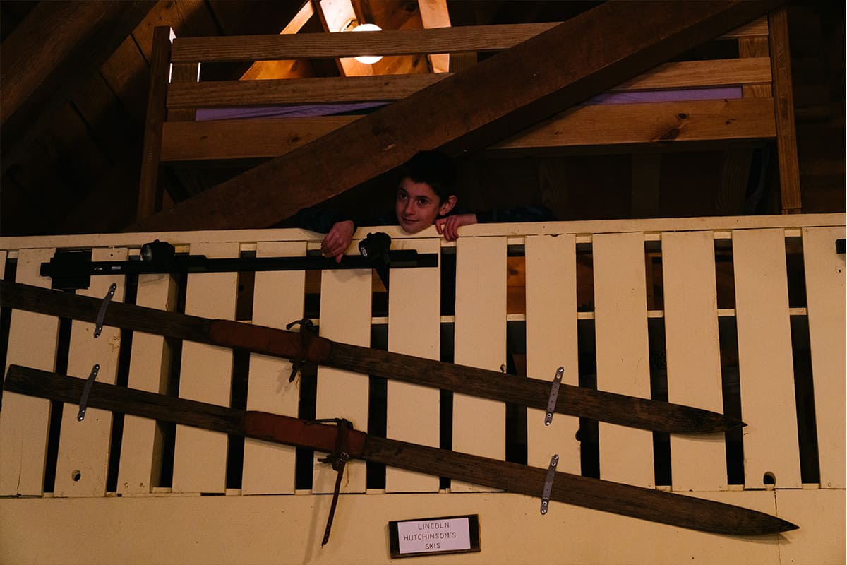 a boy leans on a railing inside the lodge