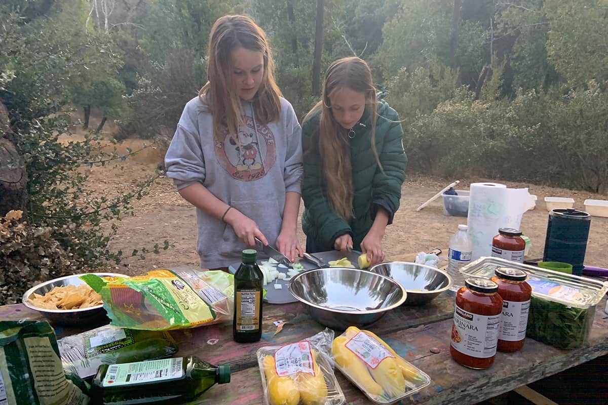 two girls prepping food outdoors